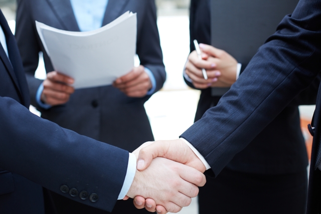 Close-up of businessmen handshaking in working environment